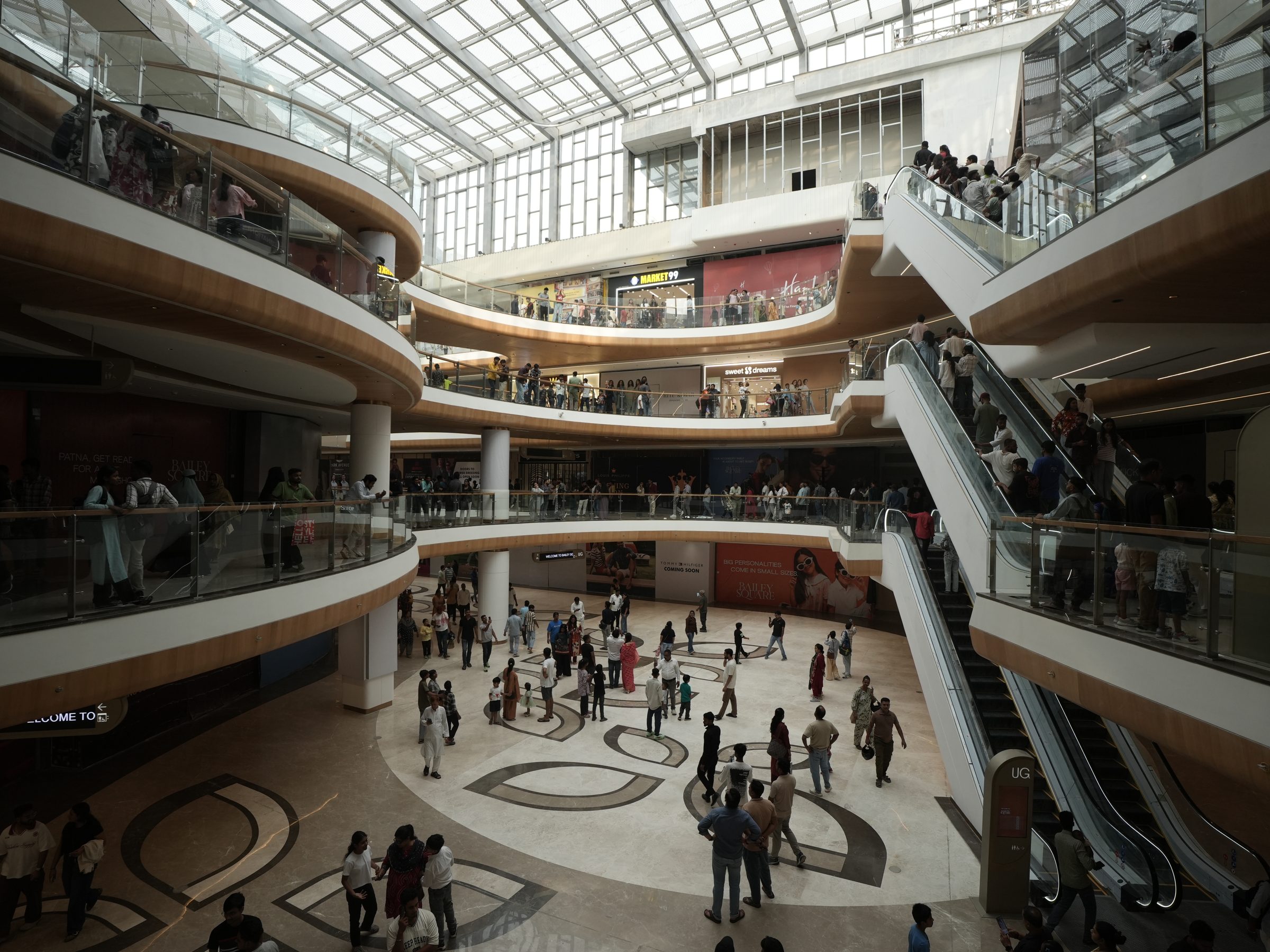 Visitors on every level of the skylit atrium at Bailey Square, Patna
